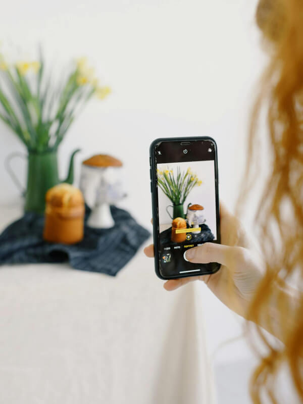 Artesã fotografando uma peça de artesanato para postar no Pinterest