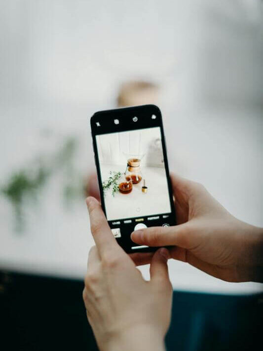 Artesã tirando foto do seu trabalho para divulgar nas redes sociais