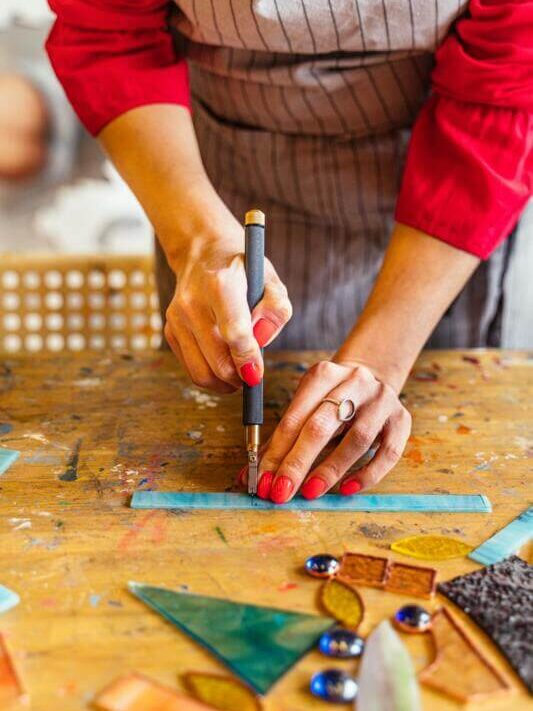 Artesão na sua bancada de trabalho fazendo artesanato para vender