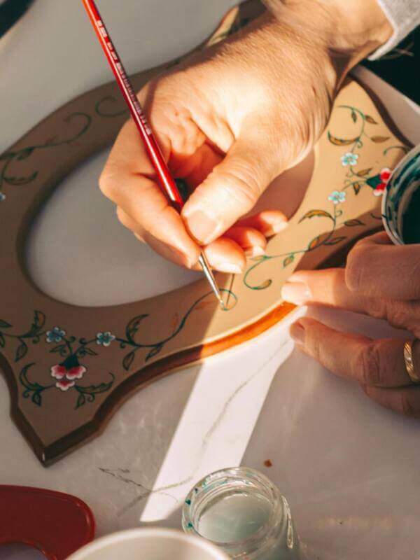 Artesã trabalhando com pintura mesmo se sentindo sem apoio da família