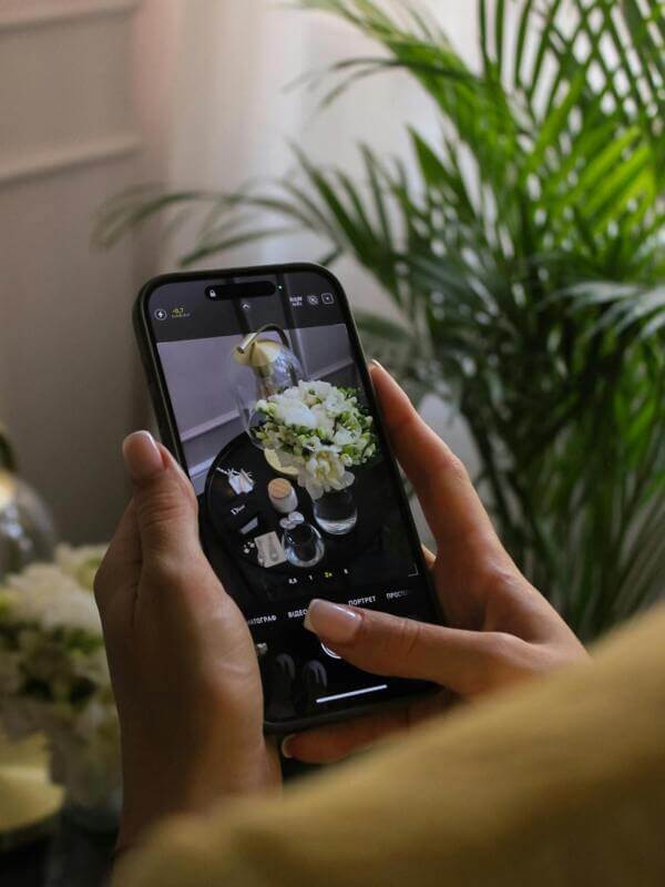 Artesão segurando o celular e fazendo foto de artesanato para divulgar nas redes sociais