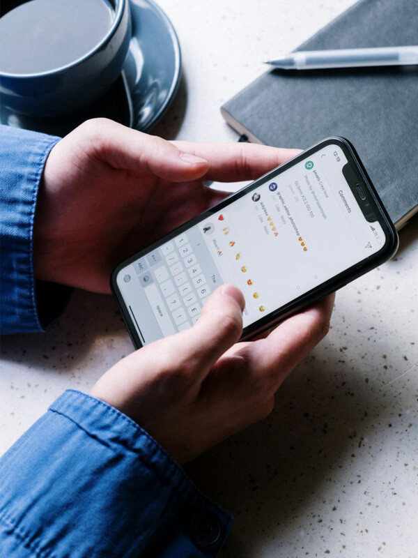 Artesã segundo o celular nas mãos e navegando pela rede social Instagram