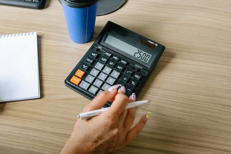 Artesão utilizando uma calculadora para calcular o preço do artesanato