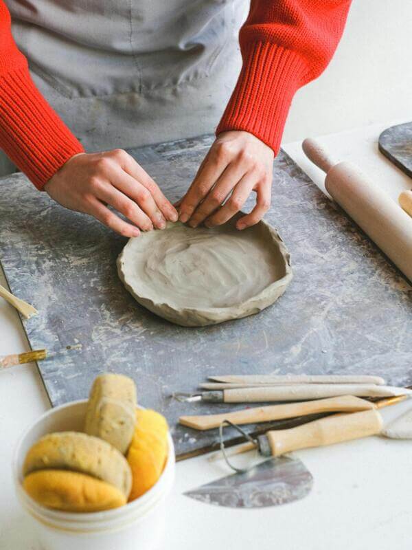 Artesã trabalhando com argila sobre uma bancada